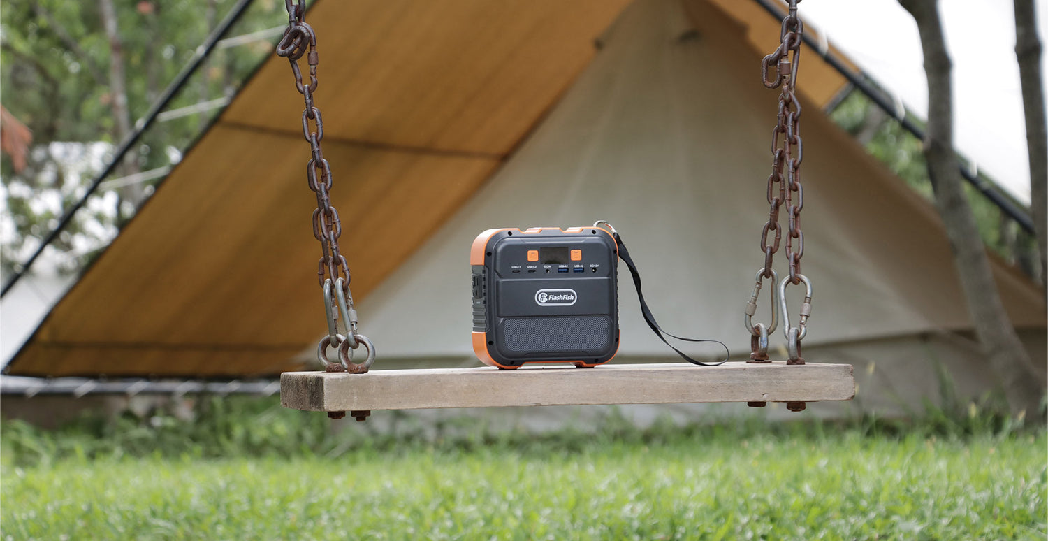 FlashFish portable power station on a swing in front of a campsite tent