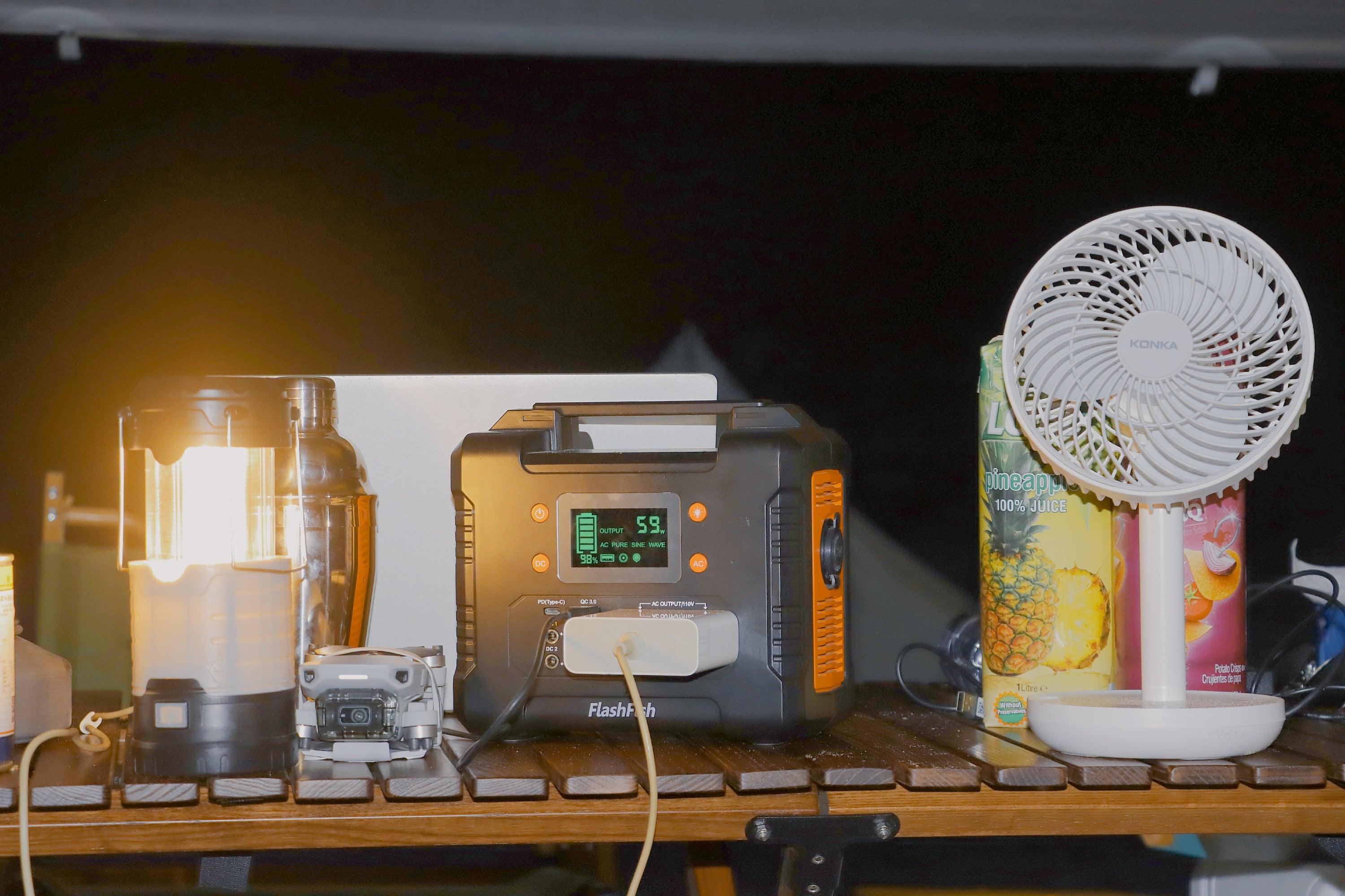 FlashFish portable power station powering a lamp and fan during an outage