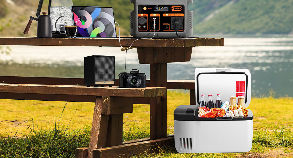 FlashFish E103 power station and small electronic devices on an outdoor table