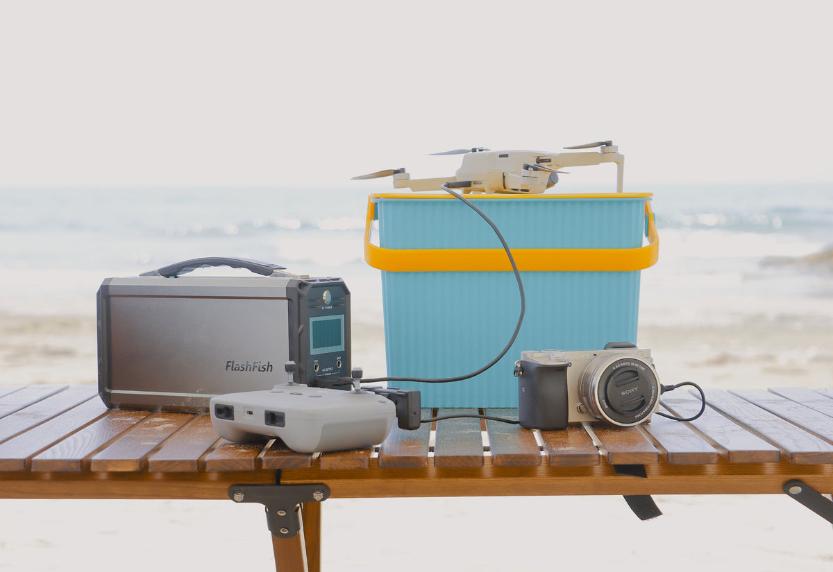 Portable power station with cameras and a small drone arranged on an outdoor equipment table
