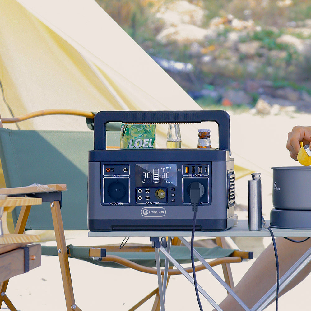 FlashFish portable power station on a campsite table beside a tent