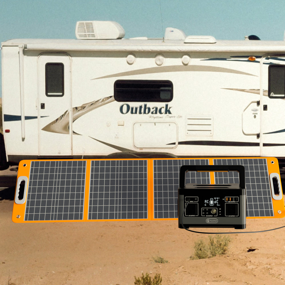 Foldable solar panel and black portable power station outdoors beside a travel trailer.