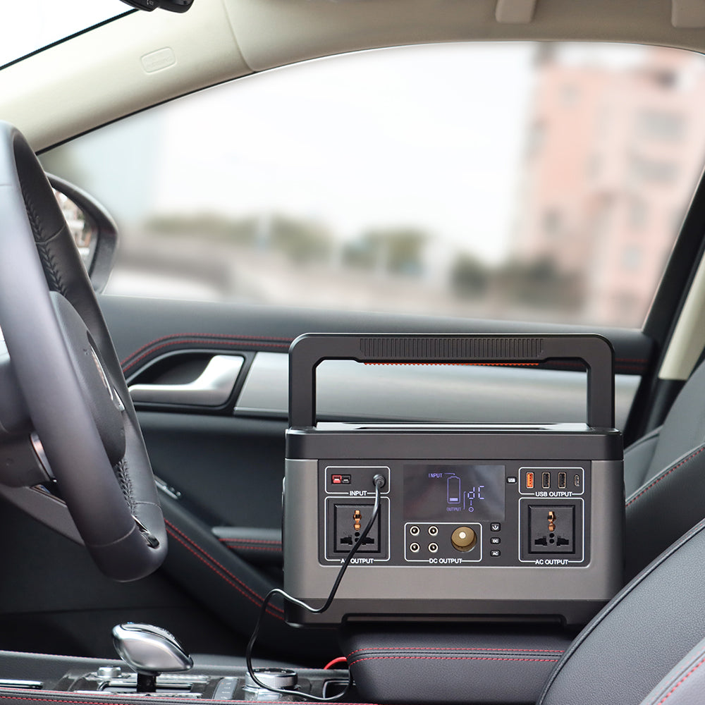 A portable power station sits on a car passenger seat beside the center console.