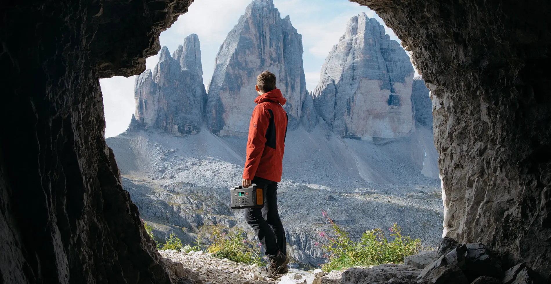 Hiker carrying a FlashFish E200 portable power station in the mountains