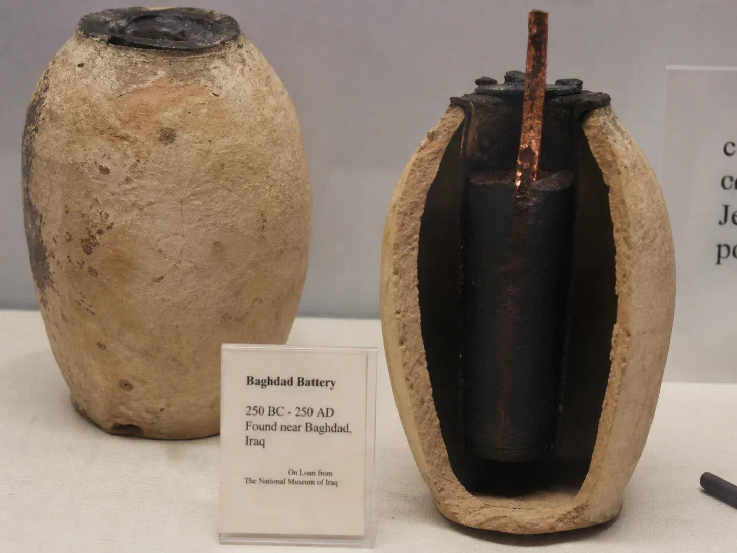 Museum display labeled Baghdad Battery with a clay jar and metal components