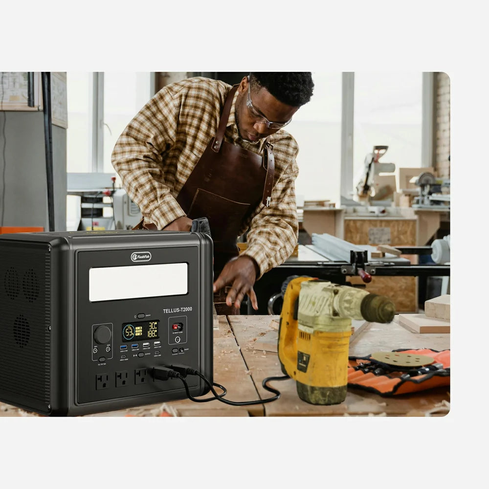 Person working at a bench beside a portable power station, drill, and tools.