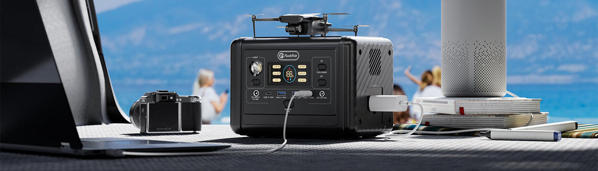 FlashFish T200 on an outdoor table beside a laptop, camera and speaker.