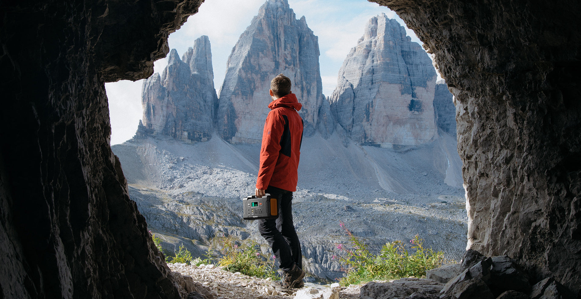 Hiker carrying a FlashFish E200 portable power station in a mountain setting