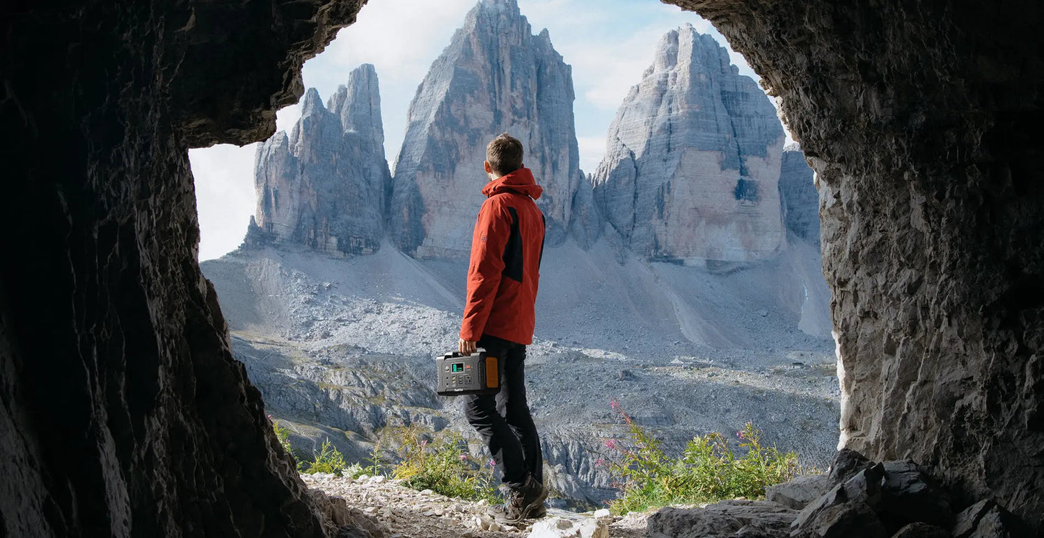 Hiker carrying a FlashFish E200 portable power station in the mountains